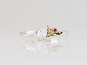 ダイヤモンドと、誕生石のシトリンとガーネットを留めた婚約指輪