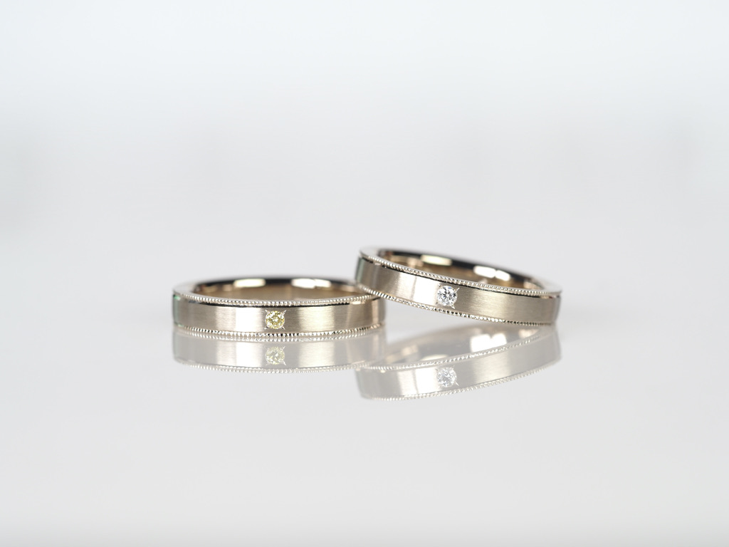 新婦様のリングにはダイヤを、新郎様のリングにはイエローダイヤを石留めし、ミルグレインを施したオーダーメイドのマリッジリングです。